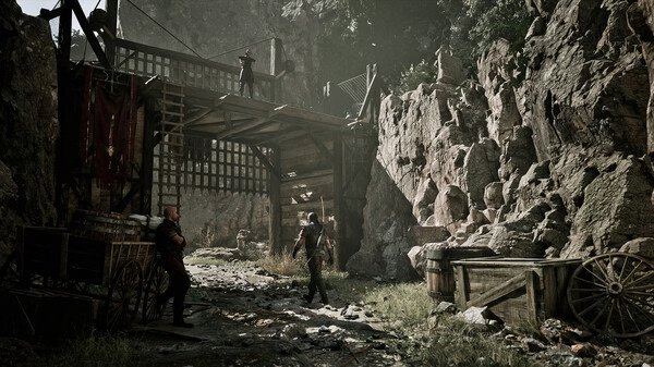 Gothic 1 Remake screenshot: A medieval scene with characters in a mountainous fortress setting, surrounded by wooden carts and rocky cliffs.