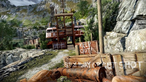 Atomfall screenshot: A weathered bus is repurposed as a structure in a rocky landscape, surrounded by warning signs.