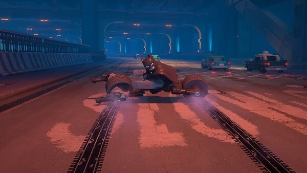 A screenshot from LEGO® Batman™: Legacy of the Dark Knight showing Batman on a Batcycle in a dimly lit underground tunnel.