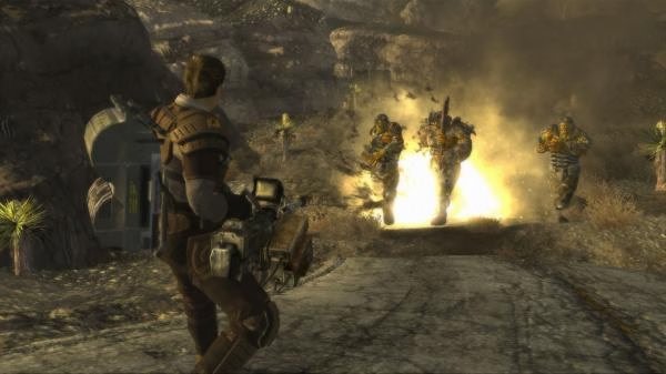 Fallout: New Vegas screenshot: A character aims a weapon at three armored figures emerging from an explosion in a desert landscape.
