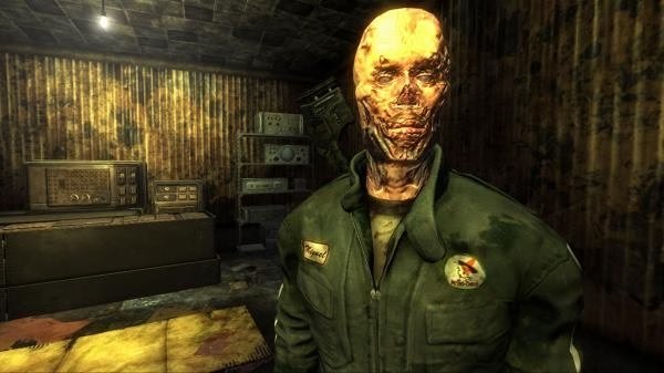 Screenshot from Fallout: New Vegas showing a character in a green jumpsuit inside a dimly lit, cluttered room.