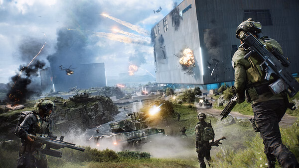 Screenshot from Battlefield™ 2042 shows soldiers advancing on a battlefield with helicopters and explosions around a large building.
