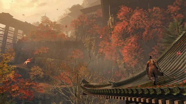 Screenshot from Sekiro™: Shadows Die Twice - GOTY Edition showing a character on a roof surrounded by vibrant autumn trees and mountains.
