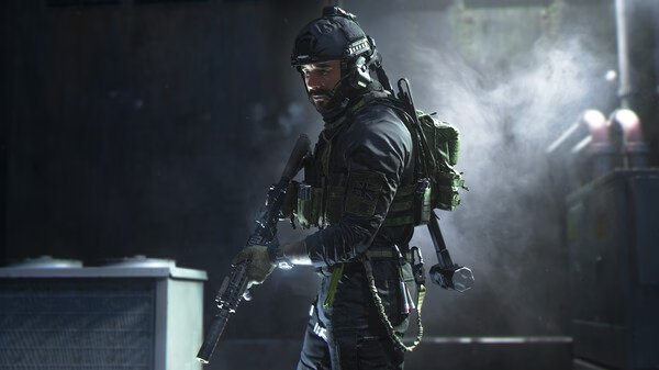A soldier in tactical gear holds a rifle in a dimly lit room in this 'Call of Duty®: Modern Warfare® II' screenshot.