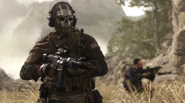 Screenshot from Call of Duty®: Modern Warfare® II showing armed soldiers in tactical gear in a grassy, mountainous environment.