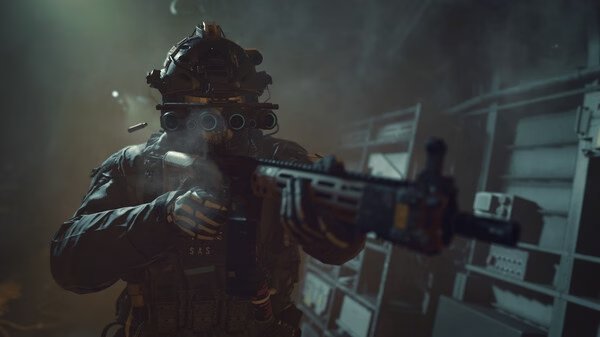 Screenshot from Call of Duty®: Modern Warfare® II showing a soldier aiming a rifle in a dimly lit, industrial environment.