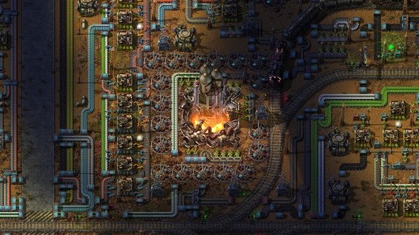 Screenshot from Factorio showing a complex factory layout with machines, conveyor belts, and a rocket silo at the center.