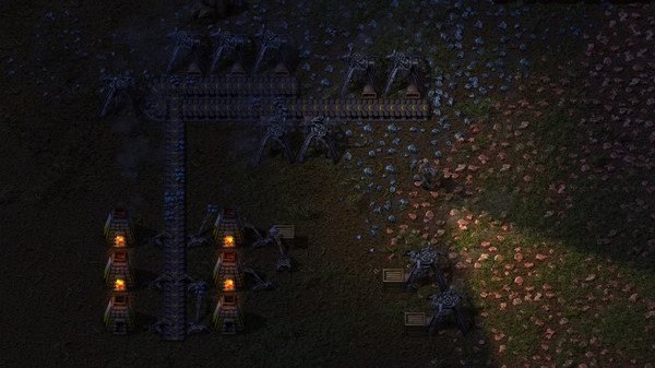 Screenshot from Factorio showing an industrial setup with conveyor belts, mining drills, and furnaces on a rocky terrain.