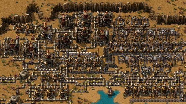 Screenshot from Factorio showing a complex factory setup with conveyor belts and machinery in a desert landscape.