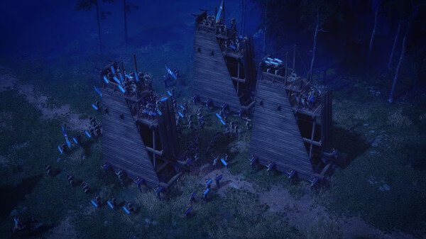 Anvil Empires screenshot: A night scene showing three wooden siege towers surrounded by soldiers in a forest clearing.