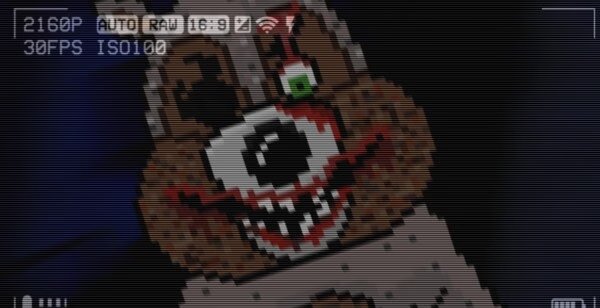 Game screenshot from The Last Night showing a pixelated, menacing bear face with one green eye and sharp teeth, resembling a video camera feed.