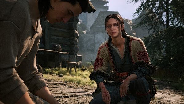 Screenshot from "The Blood of Dawnwalker": Two characters in detailed medieval attire converse in a rustic village setting.