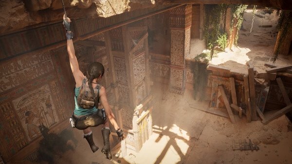 Screenshot from Tomb Raider: Legacy of Atlantis showing the protagonist hanging from a rope in an ancient, sunlit temple.