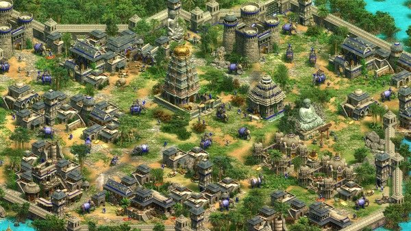 Age of Empires II screenshot showing a vibrant cityscape with temples, fortified structures, and elephants roaming the streets.