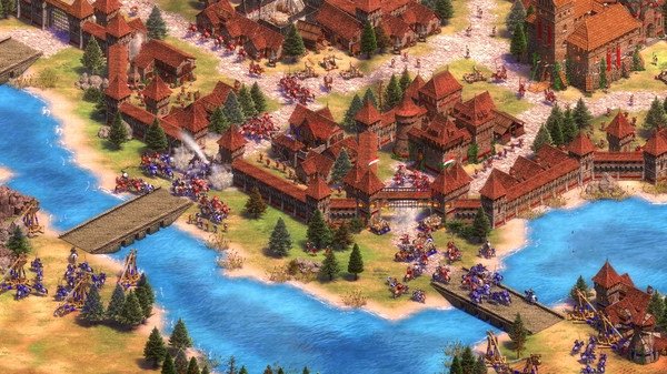 Screenshot from Age of Empires II showing a medieval battle near a river with armies, trebuchets, and red-roofed buildings.