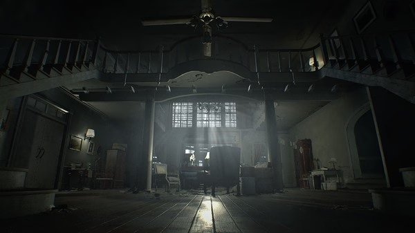 Screenshot from Resident Evil 7 Biohazard showing an eerie, dimly lit mansion interior with a grand staircase and scattered furniture.