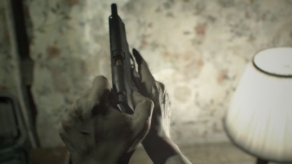 Resident Evil 7 Biohazard screenshot: A person holds a handgun in their hands, with a lamp and floral wallpaper in the background.