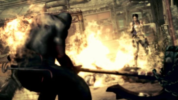 Resident Evil 5 screenshot: A burning scene shows a figure wielding a weapon facing a character standing amidst flames and debris.
