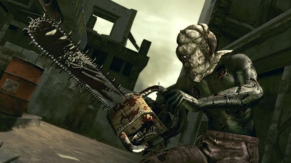 Resident Evil 5 screenshot showing a Chainsaw Majini enemy wearing a sack mask, holding a chainsaw in a dilapidated urban area.
