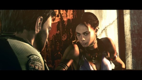 Resident Evil 5 screenshot: Two characters stand in a dimly lit area, one facing the wall, wearing tactical gear.