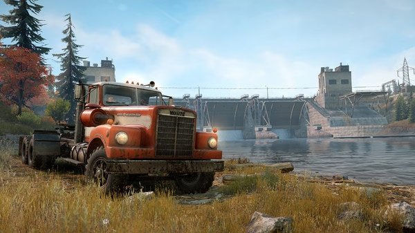 Screenshot from SnowRunner showing a red truck parked near a river with a large dam in the background on a sunny day.