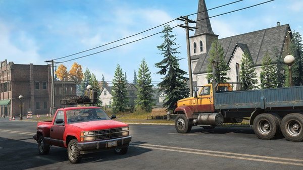 SnowRunner screenshot: A red pickup truck and a yellow flatbed truck are parked on a street near a church and trees under a clear blue sky.