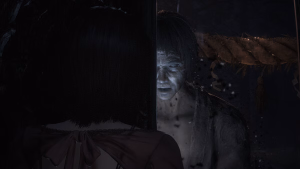 Screenshot from FATAL FRAME II: Crimson Butterfly REMAKE showing a ghostly figure facing a woman in a dark, eerie setting.