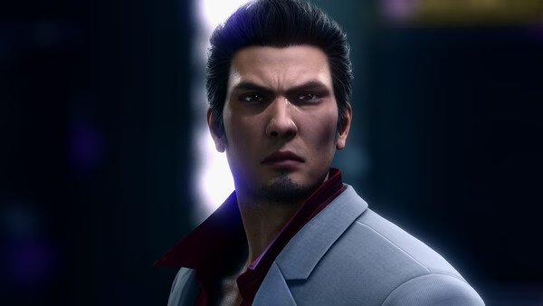 A Yakuza Kiwami 2 screenshot featuring a man in a gray suit with a red shirt collar, set against a dark, glowing backdrop.