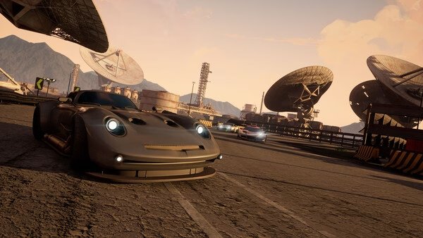 Screamer screenshot: A sleek sports car speeds on a race track with satellite dishes and mountains in the background.