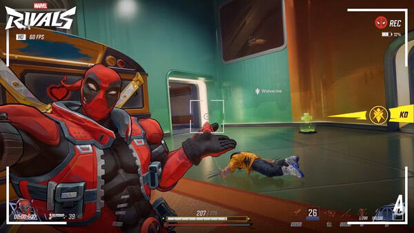 Marvel Rivals screenshot: A character in a red suit gestures towards a defeated opponent on the futuristic game map.
