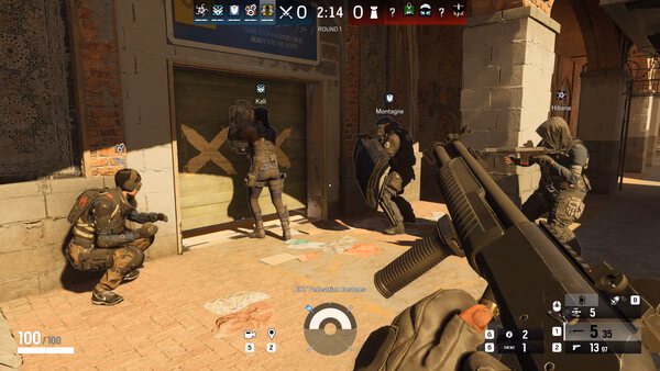 Screenshot from Tom Clancy's Rainbow Six Siege showing players breaching a barricaded door, with operators Kali and Montagne in action.