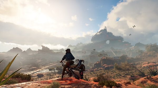 Star Wars Outlaws screenshot: A lone biker overlooks a vast desert landscape with distant TIE fighters in the sky.