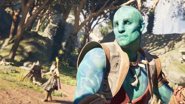 Screenshot from Avowed: A blue-skinned character stands in a lush forest, with another figure visible in the background.