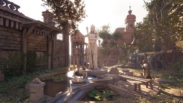 Avowed screenshot: A serene garden with a central statue surrounded by water lilies and a person kneeling nearby.