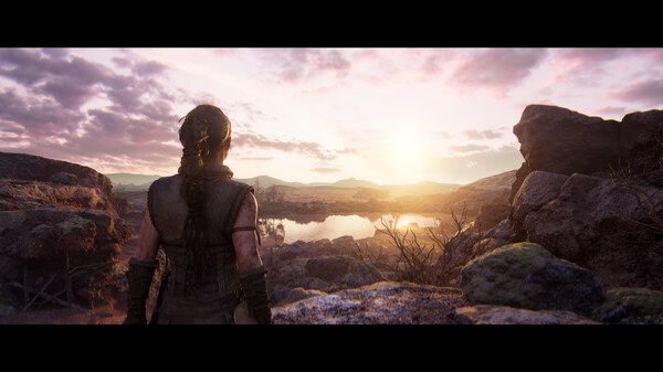 A screenshot from Hellblade II: Senua’s Saga showing Senua gazing at a stunning sunset over a rocky landscape.