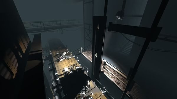 Portal 2 screenshot showing a dark, industrial area with debris scattered on platforms and walkways under dim lighting.