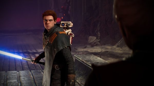 A STAR WARS Jedi: Fallen Order screenshot showing the protagonist with a lightsaber and BD-1 on his shoulder in a dimly lit setting.