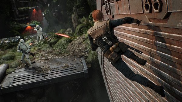 Cal Kestis clings to a wall in a jungle setting as Stormtroopers fire blasters in this 'STAR WARS Jedi: Fallen Order' screenshot.