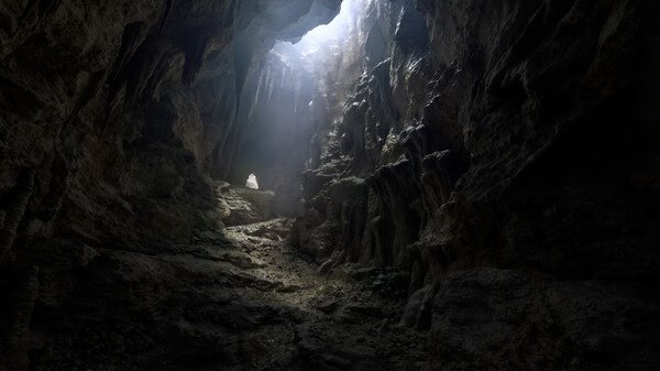 Fatekeeper screenshot: A dimly lit cavern with rugged walls and a beam of light illuminating the entrance.
