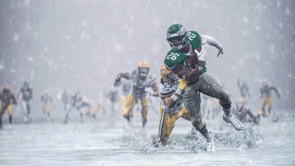 EA SPORTS Madden NFL 26 screenshot featuring a player wearing green (#26) breaking tackles in heavy snow during a football game.
