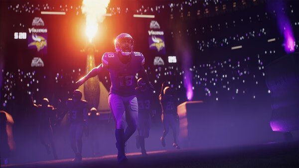 EA SPORTS Madden NFL 26 screenshot: Players in Minnesota Vikings jerseys run onto the field surrounded by stadium lights and smoke.