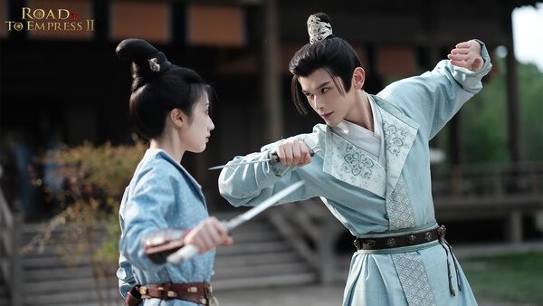 Screenshot from Road to Empress II showing two characters in traditional attire engaged in a sword duel outside a wooden building.