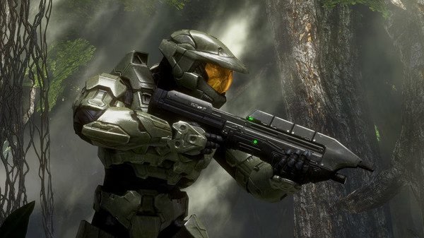 Screenshot from Halo: The Master Chief Collection showing Master Chief in armor, holding a gun in a lush forest setting.