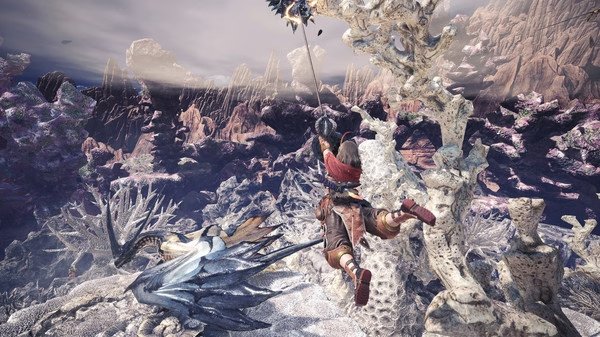 Monster Hunter: World screenshot featuring a hunter mid-air, aiming a weapon at a dragon-like creature in a rugged landscape.
