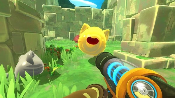 Screenshot from Slime Rancher showing a player aiming a vacuum tool at a yellow slime in a grassy stone ruin environment.