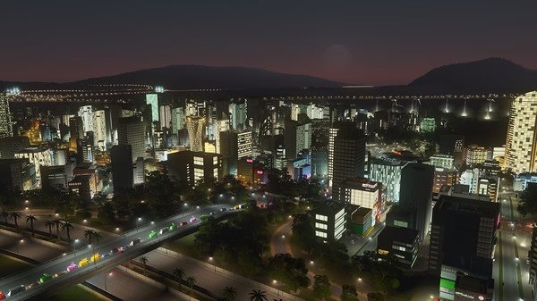 A Cities: Skylines screenshot showcasing a vibrant cityscape at night, with lit-up skyscrapers, roads, and bridges.