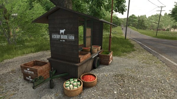 Farming Simulator 25 screenshot: A rustic produce stall labeled "Hickory Brook Farm" with crates of vegetables by a country road.