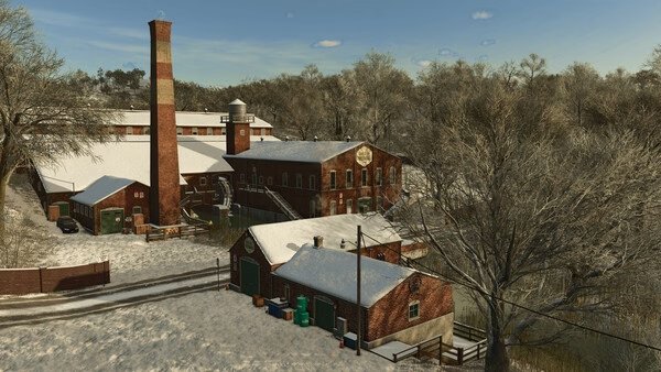 Screenshot from Farming Simulator 25 showing a snow-covered farm with brick buildings and bare trees in a winter landscape.