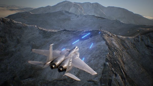 A fighter jet soars over snowy mountains in an ACE COMBAT 7: SKIES UNKNOWN screenshot, with blue tracer rounds visible.