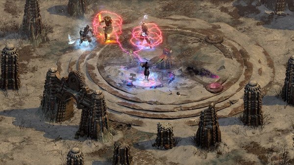 Diablo II: Resurrected screenshot showing four characters battling in a circular arena surrounded by stone structures.